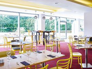 restauracja ze stołami, krzesłami i oknami w obiekcie ibis Styles Crewe w mieście Crewe