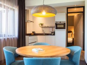 uma cozinha e uma mesa e cadeiras num quarto em Adagio Amsterdam City South em Amstelveen