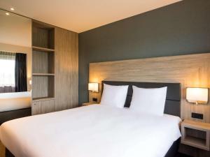 sypialnia z dużym białym łóżkiem z 2 lampami w obiekcie Adagio Amsterdam City South w mieście Amstelveen