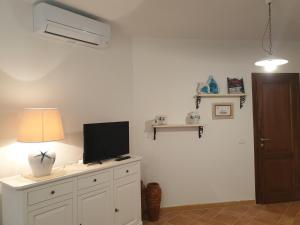 a living room with a tv on a white cabinet at Capo Figari 9, appartamento a Golfo Aranci in Golfo Aranci