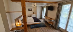 a bedroom with a bunk bed and a television at Hôtel Restaurant Cave Bel-Air in Praz