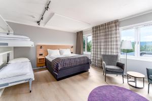 um quarto de hotel com uma cama e uma cadeira em Birkebeineren Hotel & Apartments em Lillehammer