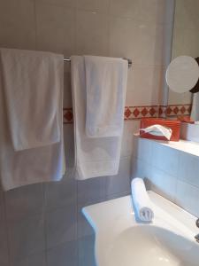 bagno con asciugamani bianchi appesi a un appendiabiti di Das Landhotel Weingut Gernert a Sankt Martin