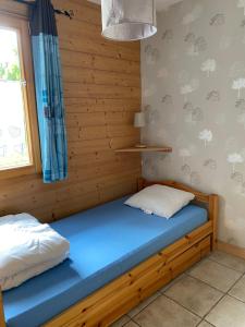 a bedroom with a blue bed and a window at gite moya in Gérardmer