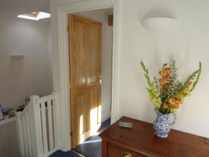 un jarrón de flores sobre una mesa en una habitación en Shepherds Row Bed and Breakfast en West Haddon