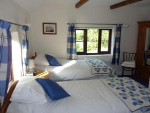 1 dormitorio con 2 camas y ventana en Shepherds Row Bed and Breakfast, en West Haddon