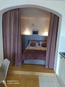 um quarto com uma cama com cortinas roxas em STUDIO APARTMAN KATARINA em Šibenik
