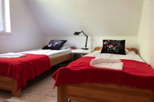 - une chambre avec 2 lits dotés de draps rouges et blancs dans l'établissement Klimatyczny Dom z widokiem na Babią Górę, à Maków Podhalański