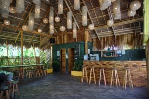 ein Restaurant mit Stühlen und eine Bar mit Lichtern in der Unterkunft Hiraya Surf Hostel in General Luna