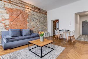 a living room with a couch and a brick wall at Design Pension Twenty 20 in Poděbrady