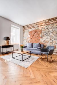 a living room with a couch and a brick wall at Design Pension Twenty 20 in Poděbrady