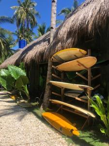 un gruppo di tavole da surf seduti fuori da una capanna di Hiraya Surf Hostel a General Luna