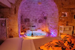 a room with a bath tub in a stone wall at Relais Il Trullo della Rupe in Ostuni