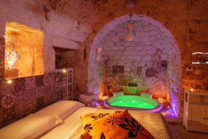 a bedroom with a tub in a stone walled room at Relais Il Trullo della Rupe in Ostuni