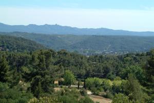 Vue sur une forêt avec des montagnes en arrière-plan dans l'établissement Pavillon de Beauregard, à Aix-en-Provence