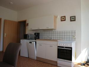 a small kitchen with white cabinets and appliances at Ferienwohnung MIWE Gesundheitszent in Forst