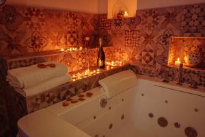 a bathroom with a tub and candles and lights at Relais Il Trullo della Rupe in Ostuni