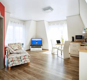 a living room with a couch and a tv and a table at Weinhaus Lenz in Briedern