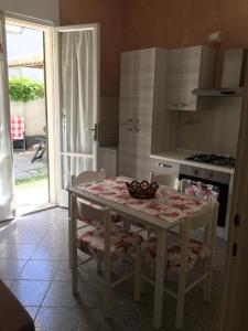 une cuisine avec une table et des chaises ainsi qu'une cuisine avec une cuisinière dans l'établissement Appartamento il delfino, à Lido di Camaiore
