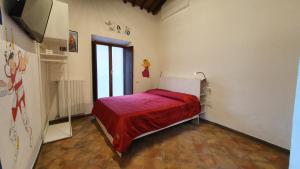 a bedroom with a bed with a red blanket at Palazzetto la Fonte in Viterbo