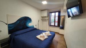 a bedroom with a blue bed with towels on it at Palazzetto la Fonte in Viterbo