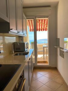 a kitchen with a view of the ocean from a balcony at Mansfield vue carte Postale Terrasse Piscine calme port à 200m à pied in Menton