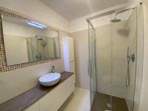 a bathroom with a sink and a glass shower at Mansfield vue carte Postale Terrasse Piscine calme port à 200m à pied in Menton +19 photos