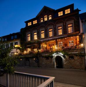 a large brick building with lights on at Weinhaus Lenz in Briedern