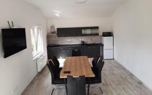 a kitchen with a wooden table and black chairs at Apartmán Vimperk in Vimperk
