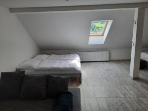 a bedroom with a bed and a couch in it at Apartmán Vimperk in Vimperk