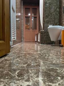 Łazienka z kamienną podłogą, wanną i drzwiami w obiekcie Kyveli Suites w Nauplionie