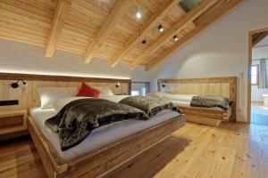 サン・ジャコモにあるTischlerhof Alpine Livingのベッドが2つあり、天井が木製の寝室