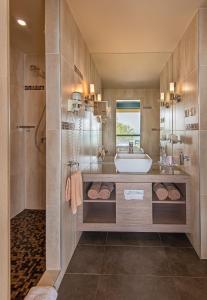 a bathroom with a tub, sink and mirror at Hotel Azur Premium in Siófok