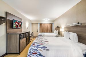 a hotel room with two beds and a tv at Red Roof Inn Dayton South - Miamisburg in Miamisburg
