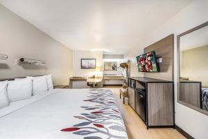 a hotel room with a bed and a flat screen tv at Red Roof Inn Dayton South - Miamisburg in Miamisburg
