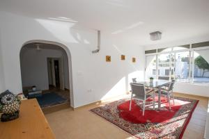 a dining room with a table and a red rug at Apartment Costa Blanca in Mutxamel