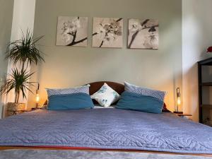 een slaapkamer met een bed met blauwe lakens en kussens bij Haus Heideblick in Undeloh