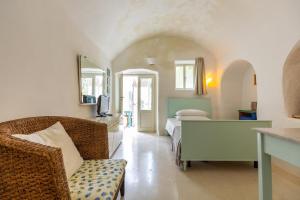 ein Schlafzimmer mit einem Sofa und einem Bett in einem Zimmer in der Unterkunft Dimora Santi-Mancuso by BarbarHouse in Presicce