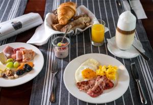 einen Tisch mit Speisen zum Frühstück und Orangensaft in der Unterkunft Hotel Hofgarten Luzern in Luzern