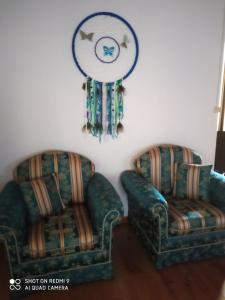 two chairs and a mirror on a wall with at CASA DOS GRILOS in Penacova