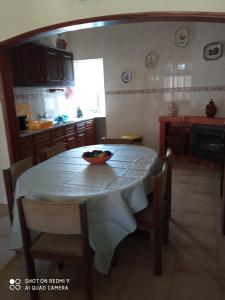 een keuken met een tafel en een fruitschaal bij CASA DOS GRILOS in Penacova