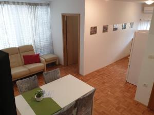 a living room with a couch and a table at Apartment EMMA Ljubljana - FREE parking, AC, Wifi in Ljubljana