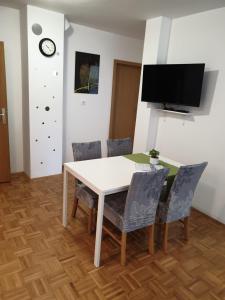 a dining room with a white table and chairs at Apartment EMMA Ljubljana - FREE parking, AC, Wifi in Ljubljana