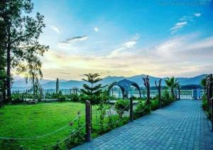 a walkway leading to a park with mountains in the background at Stay Inn Hotel in Mingāora