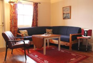 a living room with a blue couch and a table at Sildpollnes Sjøcamp in Vestpollen