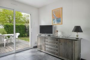 a living room with a television on a dresser at Maison neuve, 200m du Port du Crouesty in Arzon