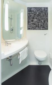 een badkamer met een wastafel, een toilet en een spiegel bij ibis Arcachon la Teste de Buch in La Teste-de-Buch