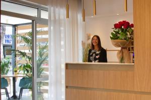 a woman standing in front of a mirror at Hotel Suez in Lido di Jesolo
