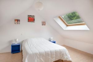 a white bedroom with a bed and two blue tables at À 200m du Port de Crouesty, Maison 6 personnes in Arzon