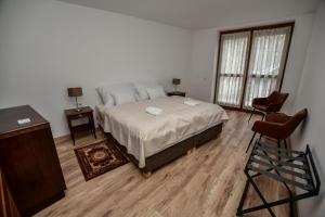 1 dormitorio con 1 cama y 2 sillas en Bodrog33 Riverhouse en Tokaj